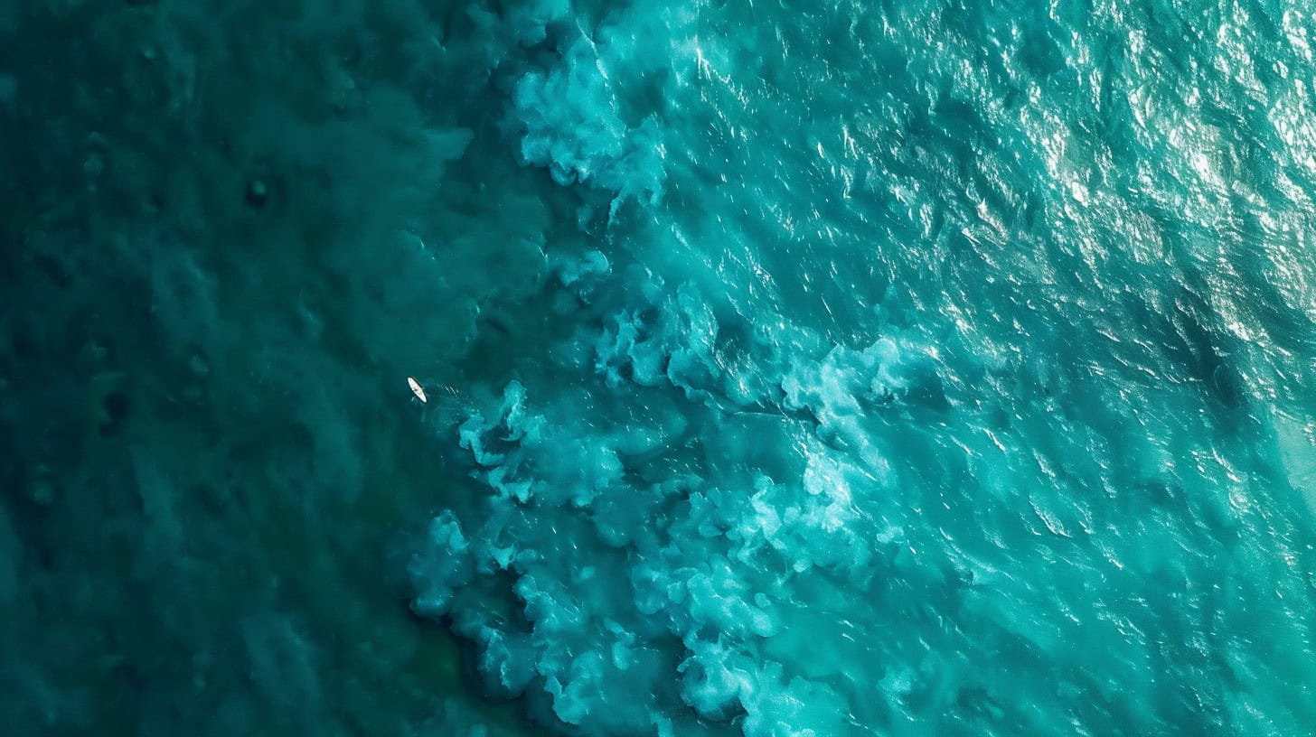 An aerial view of turquoise ocean waves, symbolizing Evonomics' tailored approach to navigating the complex currents of AI integration.